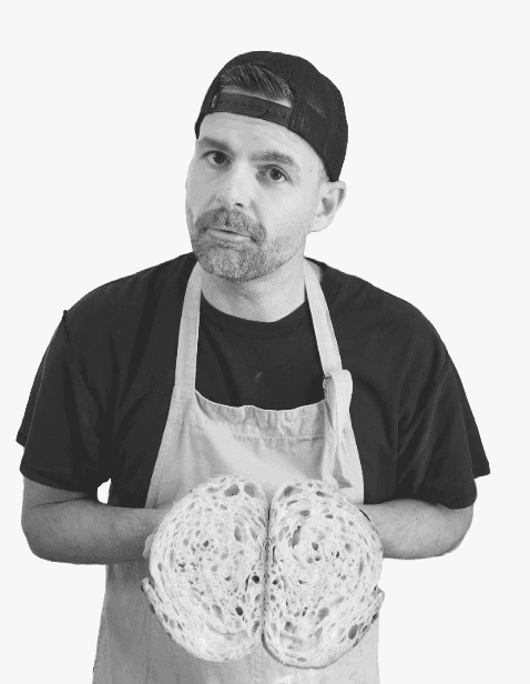 Dan Cordeiro, founder of Bakery OS, holding a loaf of sourdough